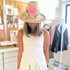 Model wearing a woven straw hat with a hand-painted pink heart and leopard print, paired with a white ribbed tank top by artist Kerri Rosenthal