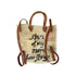 Back view of a hand-painted straw tote bag with 'Star of my own love story' script and tan leather handles handpainted by artist Kerri Rosenthal
