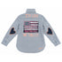 Denim shirt hand-painted on the back with 'In Love We Trust' text framing a fringed American flag patch with pink heart accents, and heart-shaped elbow patches on both sleeves — Kerri Rosenthal wearable art