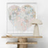 Decorative table with a large abstract painting and a modern lamp against a white wall.