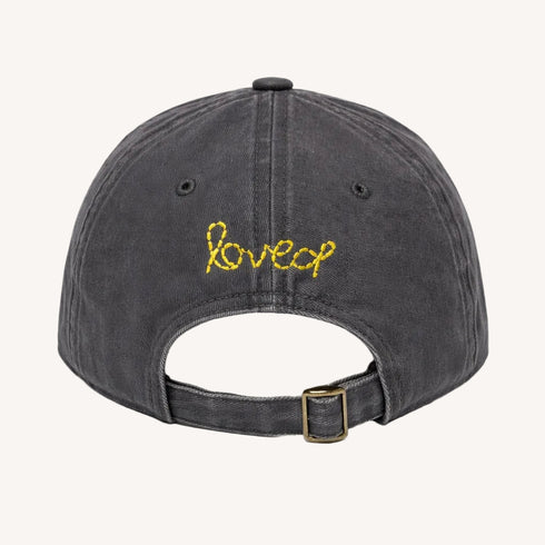Back view of KR Imperfect heart coal baseball cap hat with yellow 'loved' embroidered on back made from 100% cotton and adjustable strap - Shop heart baseball caps by Kerri Rosenthal