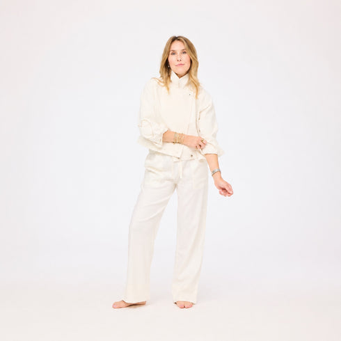 Woman wearing a white outfit on a plain background