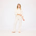 Woman wearing a white outfit on a plain background