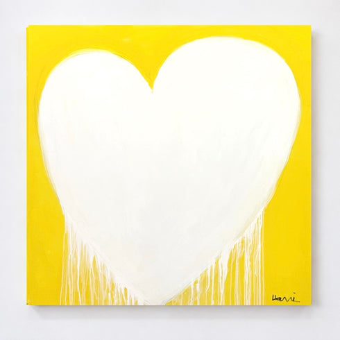 A square canvas painting featuring a large white heart shape with dripping paint details on a bright yellow background, shown against a light gray wall.