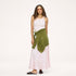 Model wearing a pale pink ribbed tank with a heart pendant necklace, an olive green cardigan tied around the waist, a blush satin maxi skirt, and black woven flats. Shop Kerri Rosenthal