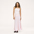 Model wearing a pale pink ribbed tank with a heart pendant necklace and a blush pink satin maxi skirt, paired with black woven flats. Shop Kerri Rosenthal