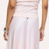 Close-up back detail of a satin blush pink maxi skirt with a small embroidered heart at the waistband
