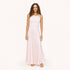 Model wearing a pale pink ribbed tank with a heart pendant necklace and a blush pink satin maxi skirt, paired with black woven flats. Shop Kerri Rosenthal
