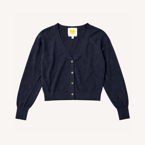 Flat lay of a Kerri Rosenthal navy cotton v-neck cardigan with gold heart buttons and yellow heart logo label."