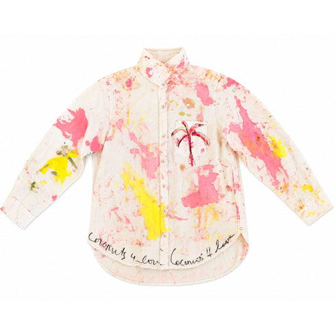 White button-down shirt hand-painted with pink and yellow paint splatters throughout, a pink palm tree on the chest pocket, and 'Coconuts 4 Love' script repeated along the hem — Kerri Rosenthal wearable art
