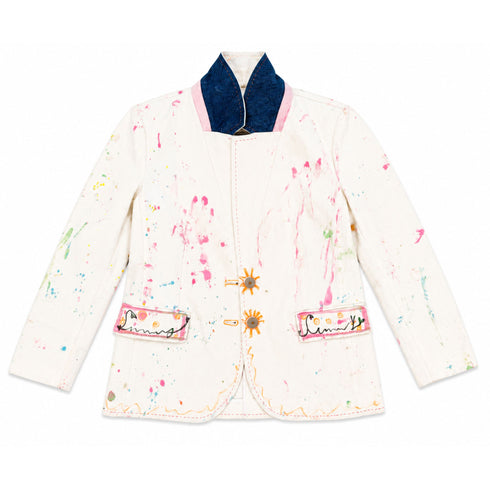 White hand-painted blazer with denim and pink collar detail, pink and multicolor paint splatters throughout, sun-shaped gold button closures, and 'Sunny' script embroidered on both front pockets — Kerri Rosenthal wearable art