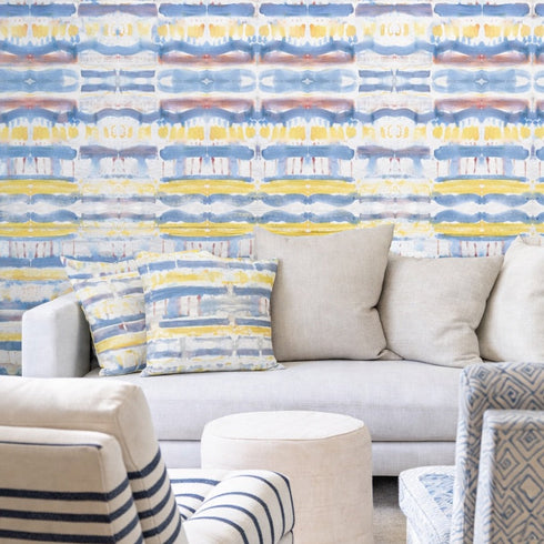 Living room with a patterned wall, sofa, and striped armchair.