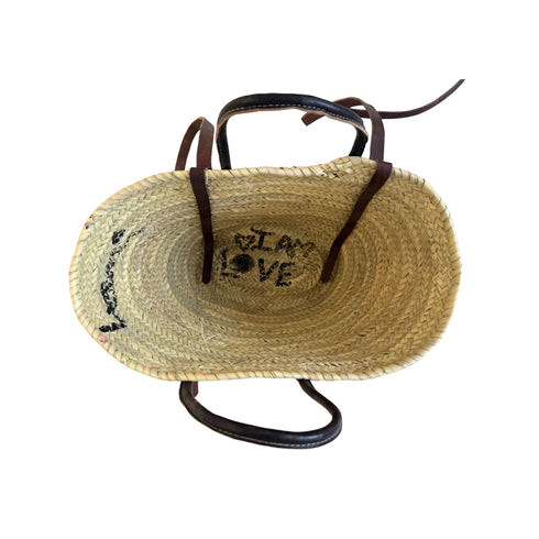 Interior view of a hand-painted straw tote bag with 'I Am Love' lettering and leather handles handpainted by Kerri Rosenthal