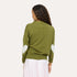 Back view of a woman wearing a Kerri Rosenthal olive green knit cardigan featuring mint green heart elbow patches, styled with a blush pink maxi skirt.
