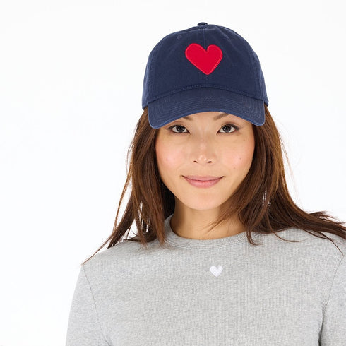 Navy blue cotton baseball cap hat with a unique Imperfect heart patch and an adjustable belt pull for a customized fit by Kerri Rosenthal