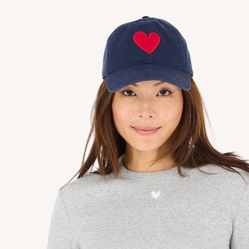 Navy blue cotton baseball cap hat with a unique Imperfect heart patch and an adjustable belt pull for a customized fit by Kerri Rosenthal