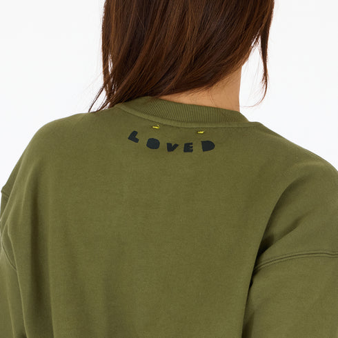 Classic green cotton fleece sweatshirt with Loved graphic at back neck and contrast imperfect heart elbow patches by Kerri Rosenthal.