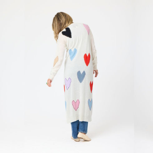 Cozy and colorful 100% cashmere long cardigan sweater duster with multicolored hand-stitched imperfect heart appliqués, front patch pockets, and ribbed cuffs.