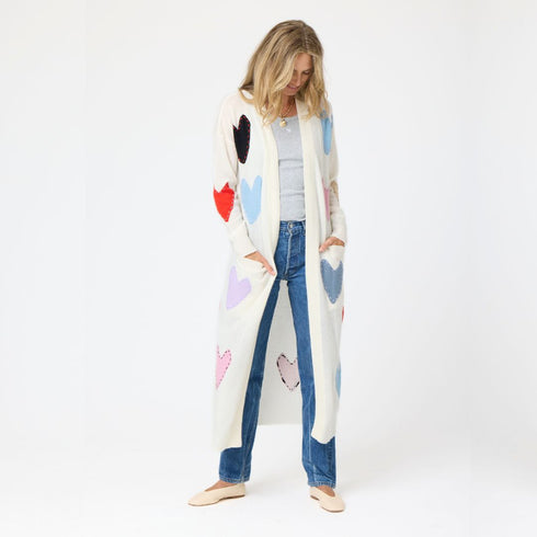 100% Cashmere long cardigan sweater duster with multicolored hand-stitched imperfect heart appliqués, front patch pockets, and ribbed cuffs.