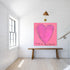 Le Temps de l'Amour art print: a magenta-pink heart on a pink background, with "Le Temps de l'Amour" hand-painted below it in black, hung in a room setting