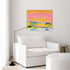 Sunset Summer art print: a pink and yellow sunset landscape hung on a pale gray wall above a white armchair, a black arc floor lamp and a wooden stool in a bright living room