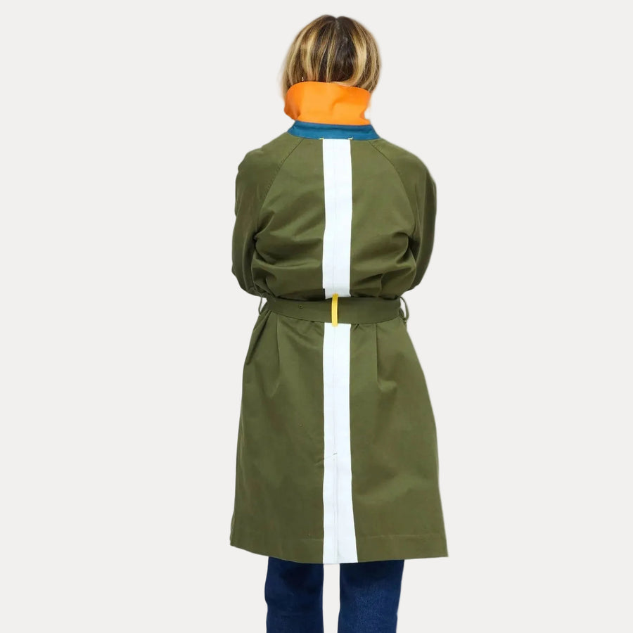 KR Trench Coat in olive green, back view showing white contrast stripe down center back and belted waist, styled with cuffed denim jeans. Shop Kerri Rosenthal jackets.