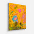 Wild Love Garden art print: a golden-orange field layered with a blue flower with a pink center, a pink blossom, olive-green patches and loose black handwritten marks, mounted under plexi with a frameless finish
