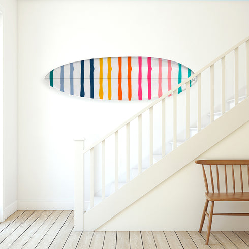 Designed with bold rainbow-like striping, this decorative surfboard brings bright, playful energy to any coastal or modern interior.
