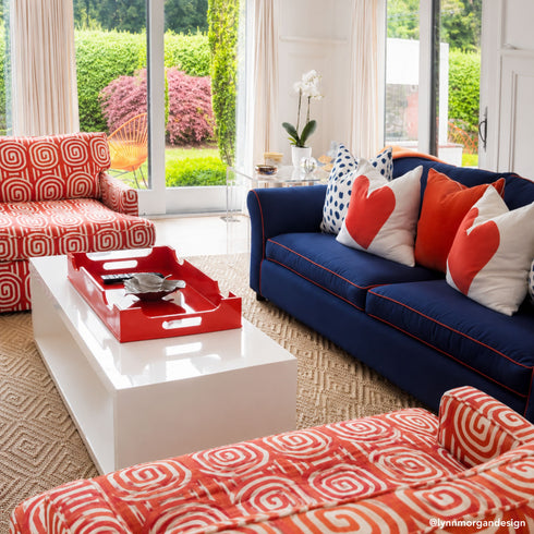 Kerri Rosenthal red heart pillow on navy blue sofa, colorful living room decor by Lynn Morgan Design.