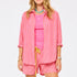 Women's pink and orange striped oversized button-down shirt and shorts co-ord set, styled with a hot pink tank top. Shop Kerri Rosenthal tank tops