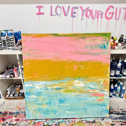 Last Light in Malibu, an abstract painting of a pink sky, golden shore, and textured turquoise water, in the studio.