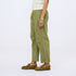 Side view of olive green drawstring pants with a cream top and tan suede loafers.
