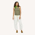 Woman wearing a green tank top with a green scarf, natural white drawstring pants, and tan suede loafers.