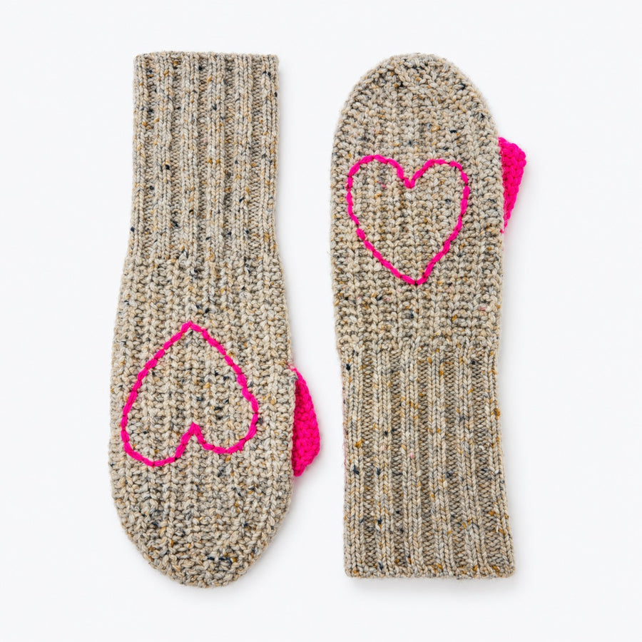 Flat view of a pair of Kisses Mittens in oatcake with a speckled knit and pink heart outlines