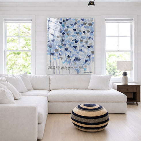 Blue and navy heart star watercolor painting above white sectional sofa, coastal living room with black and white striped ottoman