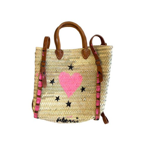 Hand-painted straw tote bag with a pink woven heart, black star motifs, and tan leather handles handpainted by Kerri Rosenthal.