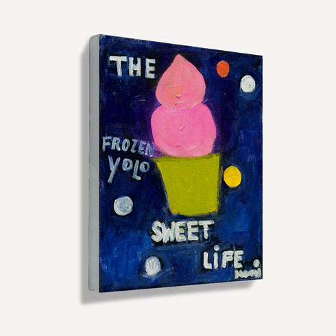 Side angle view of unframed frozen yogurt painting showing canvas texture, pink swirl dessert on navy background with playful text