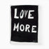 A playful way to share the positive love message "Love More" A black and white original word wall art painted by Kerri Rosenthal