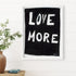 "Love More" A black and white framed original word wall art painted by Kerri Rosenthal