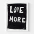 A playful way to share the positive love message "Love More" A black and white framed original word wall art painted by Kerri Rosenthal