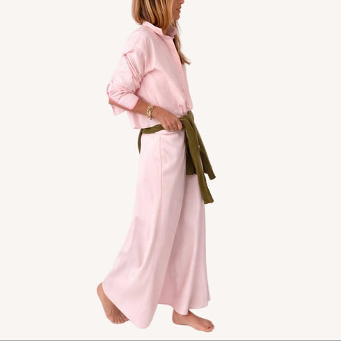 Side view of a pink striped shirt with 'LOVE' lettering and heart elbow patches and pink maxi skirt and army green sweater wrapped around waist.