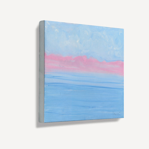 Side angle view of unframed abstract seascape canvas art, showing gallery-wrap texture with soft blue and pink coastal tones