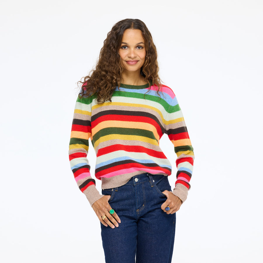 Model wearing the Patchwork Pullover Stripe Sweater in multicolor stripe with jeans, hands in her pockets, front view