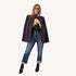Woman wearing a coal blazer with cuffed jeans, black ankle boots, and glasses.