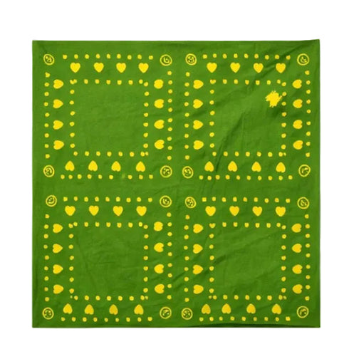 Close-up detail of green fabric with a yellow heart and dot border print and a smiley face icon by Kerri Rosenthal