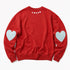 A red crewneck sweatshirt shown from the back, featuring a small white 'LOVED' text print at the center of the neck and two light blue heart patches on each sleeve, laid flat against a white background.