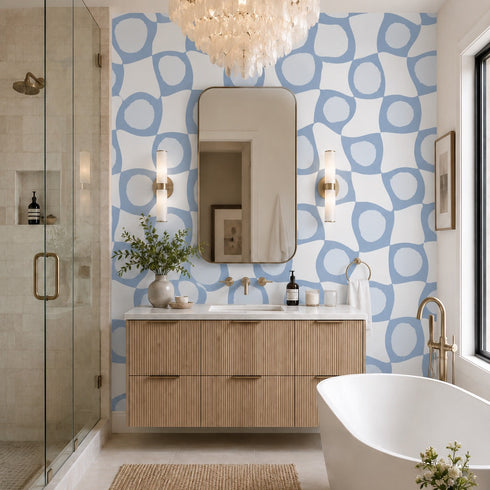 Modern bathroom with blue patterned wallpaper, wooden vanity, and white bathtub.