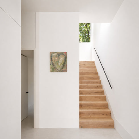 Heart Notes II, an original painting of a heart in sage, cream, and soft neutrals with flashes of pink on textured canvas, on a white wall by a staircase.