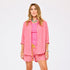 Women's pink and orange striped oversized button-down shirt and shorts set.