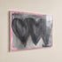 Close-up of hand-painted 3 black connecting hearts and gray and pink background texture and brushstrokes on Holding Hearts art print in plexi frame by Artist Kerri Rosenthal.